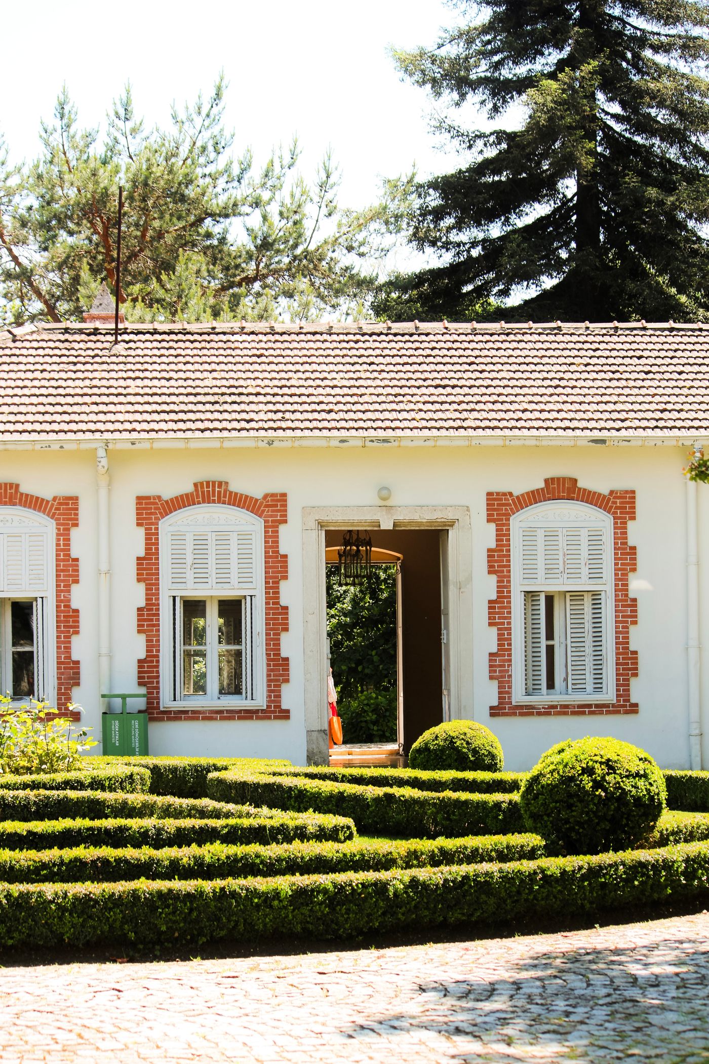 Gepflegter Garten mit Formschnitthecken an einem Haus