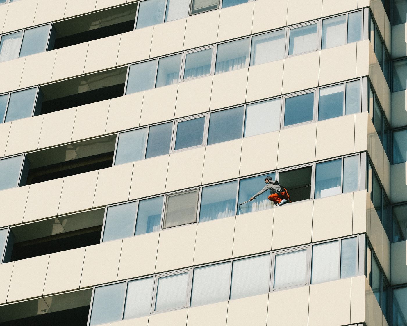 Fassadenreiniger reinigt die Fenster einer Hausfassade